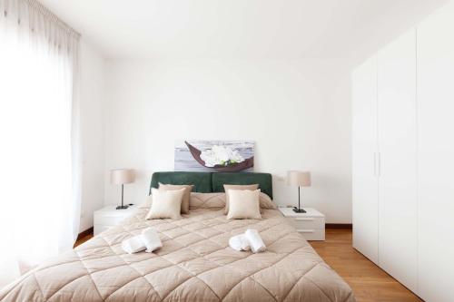 a bedroom with a large bed with two white towels on it at Attico Ai Cedri in Verona