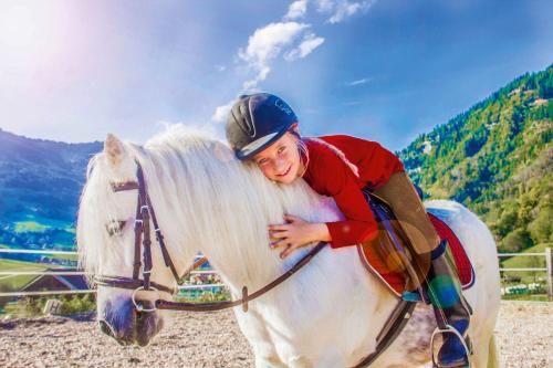 a young boy sitting on a white horse at Tobhartbauer in Dorfgastein
