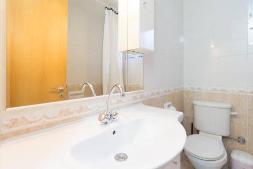 a bathroom with a white sink and a toilet at Pissouri Beach Apartments in Pissouri