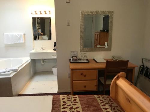 a bathroom with a desk and a sink and a tub at Cactus Tree Inn in Oliver