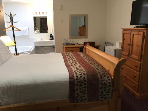 a bedroom with a bed and a dresser at Cactus Tree Inn in Oliver