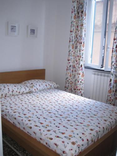 a bedroom with a bed with a comforter and a window at Una Porta sul Porto Antico in Genova