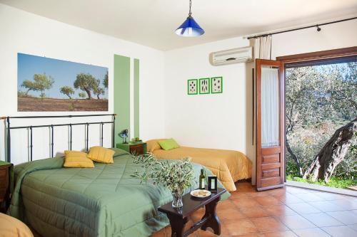 a bedroom with a bed and a sliding glass door at Azienda Agrituristica Bergi in Castelbuono
