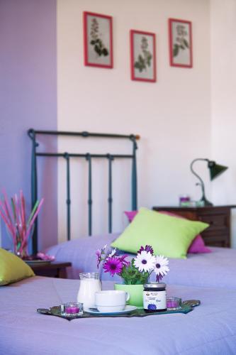 a tray of food and flowers on a bed at Azienda Agrituristica Bergi in Castelbuono
