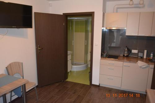 a kitchen with a door leading to a bathroom at Apartamenty i pokoje "U Dawida" in Mrzeżyno