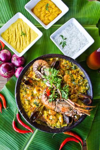 a plate of food with seafood and rice on a table at CASA Di VINA Boutique Hotel in Salvador