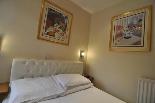 a bedroom with a bed and two pictures on the wall at The Roundabout Hotel in Fareham