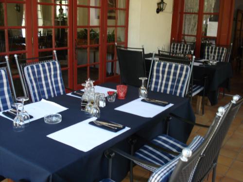 une table avec des tables et des chaises bleues dans une pièce dans l'établissement Relais du Château, à Saint-Blancard
