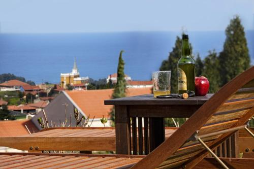 a table with two bottles of wine and an apple on a balcony at La Era De Somao in Somado