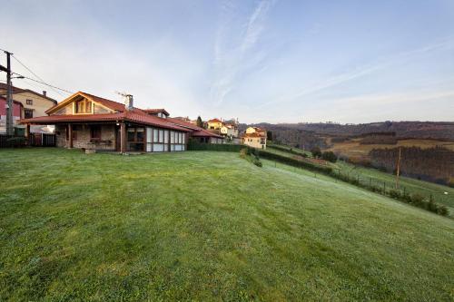 a house on a hill with a large grass field at La Era De Somao in Somado