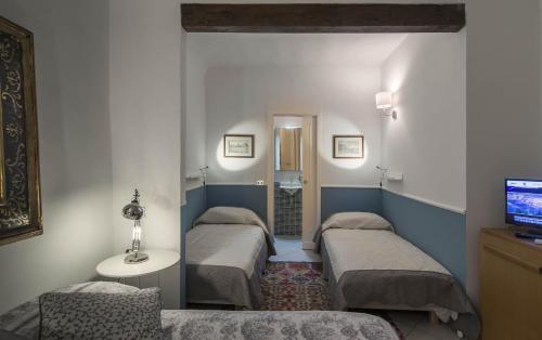 um quarto com três camas e uma televisão em Close to Michelangelo em Florença