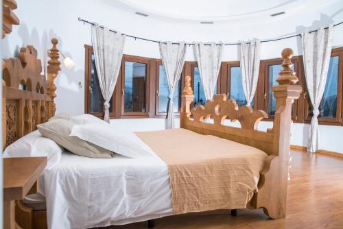 a bedroom with a bed with a wooden headboard and windows at Complejo Hostelero Paladium in Villamartín