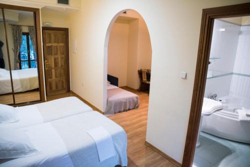 a bedroom with a bed and a sink and a mirror at Complejo Hostelero Paladium in Villamartín