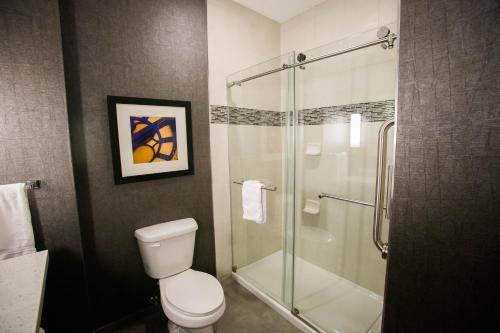 a bathroom with a toilet and a glass shower at Holiday Inn Longview - North by IHG in Longview