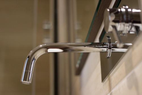 a bathroom sink with a faucet and a mirror at Arena Luxury Suite in Verona