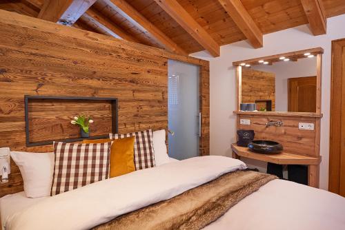 a bedroom with a bed and a wooden wall at Alpvilla Bietsch in Oberstdorf