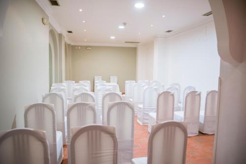 a room with white chairs and tables in a room at Complejo Hostelero Paladium in Villamartín
