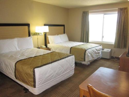 a hotel room with two beds and a table at Extended Stay America Select Suites - Austin - Round Rock - North in Round Rock
