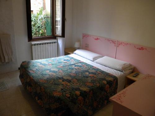 een slaapkamer met een bed met een kleurrijke quilt bij Hotel Adua in Venetië
