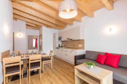 sala de estar con mesa, sofá y cocina en Apart Ida en Sölden