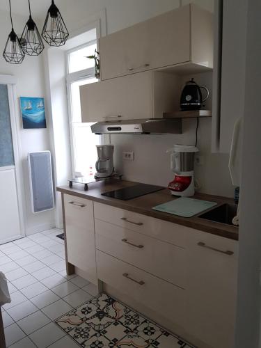 a kitchen with white cabinets and a counter top at T2 terrasse de charme à Rochebonne 400 m plage in Saint Malo