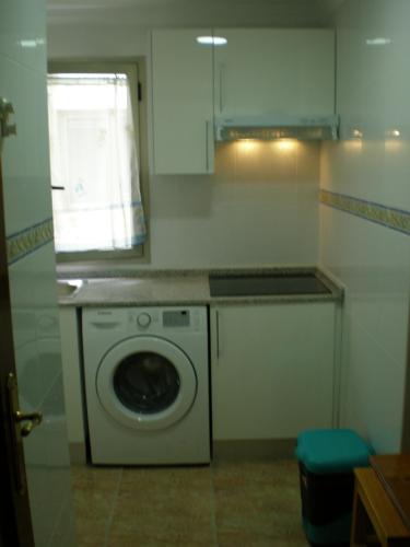 a kitchen with a washing machine and a window at A Un Paso Del Mar in Arinaga