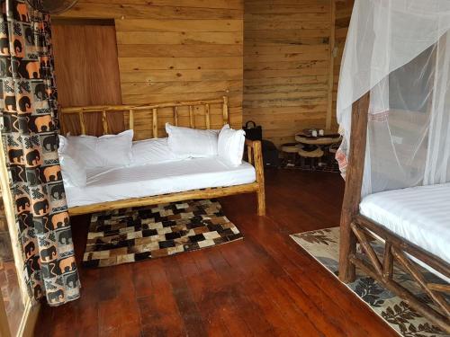 a bedroom with a bed in a log cabin at Living Waters Resort in Jinja