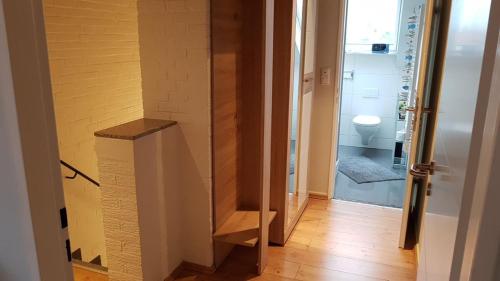 einen Flur mit Bad mit WC und Tür in der Unterkunft PEMATRA Ferienwohnung Unterm Dach in Travemünde
