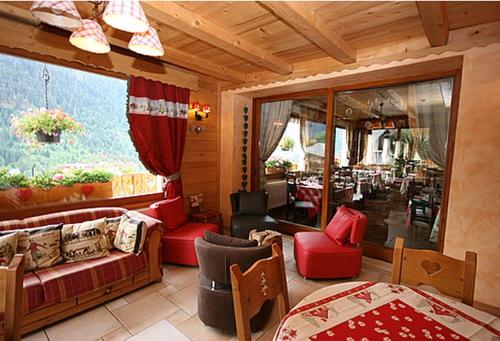 sala de estar con muebles de color rojo y ventana grande en Le Castellan, en Châtel