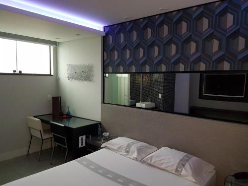 a bedroom with a bed and a desk and a mirror at Style Hotel ( Adults Only) in Sao Paulo