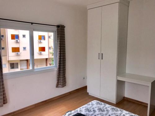 a living room with a window and a white cabinet at Apartamento no Centro de Gramado in Gramado