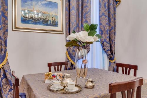 a dining room table with a vase of flowers on it at Venetian Infinity in Venice