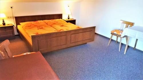 a bedroom with a bed and a table and chairs at Penzion Sumavacek in Bayerisch Eisenstein