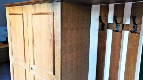 a wooden closet with a door in a room at Penzion Sumavacek in Bayerisch Eisenstein