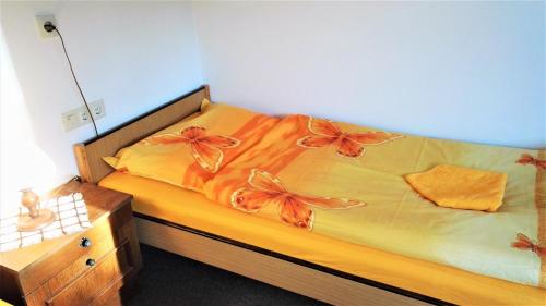 a bedroom with a bed with orange flowers on it at Penzion Sumavacek in Bayerisch Eisenstein