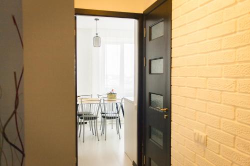 eine Tür, die in ein Esszimmer mit einem Tisch führt in der Unterkunft Sky the Apartment Centre in Tiraspol