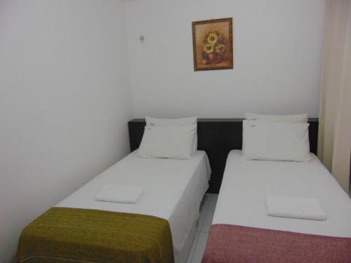 duas camas sentadas uma ao lado da outra num quarto em Aldenora Flats em Fortaleza