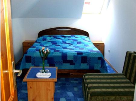 A bed or beds in a room at Hudi-Lak Vendégház