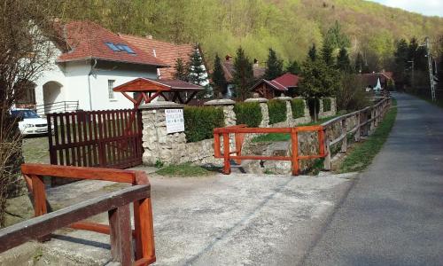 a fence in front of a house with a building at Hudi-Lak Vendégház in Háromhuta