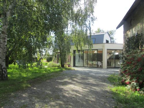 a house with glass windows and a driveway at La Petite Charnasserie in Angers