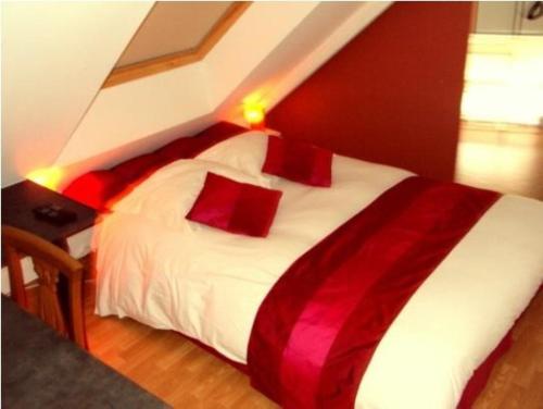 QuévenにあるAuberge An Douarのベッドルーム(白いベッド、赤い枕付)