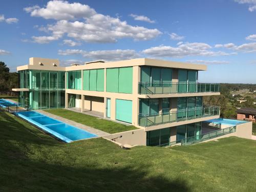 ein großes Haus mit Pool auf einem Hügel in der Unterkunft SYRAH Bahía by depptö in Punta del Este