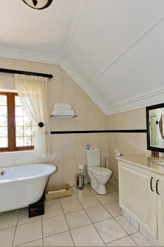 Un baño con bañera, inodoro y lavabo. en Eagle Wind Manor, en Hillcrest