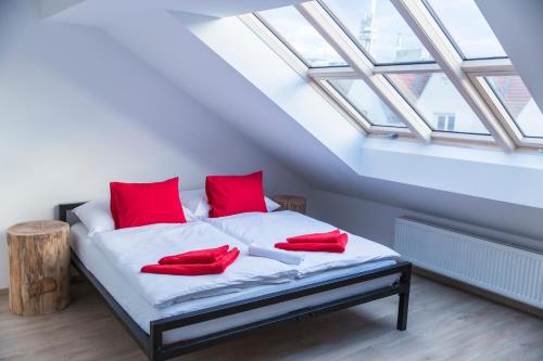 غريغوري هاوس في براغ: غرفة نوم عليها سرير ومخدات حمراء