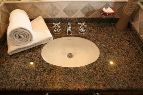 a bathroom counter with a sink with a towel on it at Hotel Ankara Suites in Salta