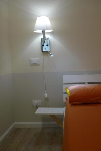 a lamp on a wall with a table and a bed at Badia in Modena
