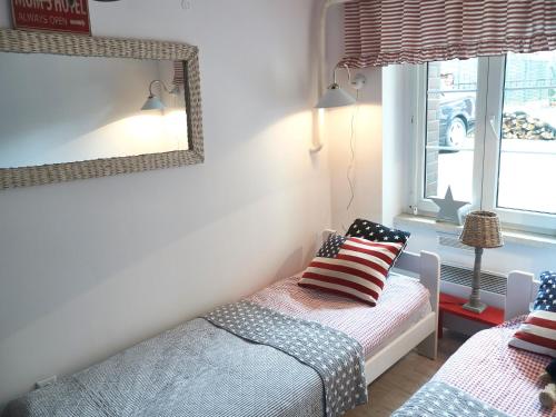 a bedroom with a bed and a mirror and a window at Mini Apartament MARINE in Świnoujście