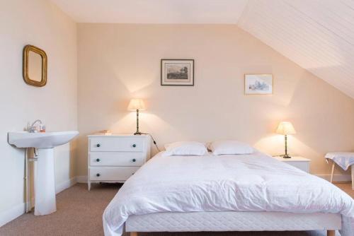 um quarto com uma cama branca e um lavatório em Chambres Saint Donatien em Nantes