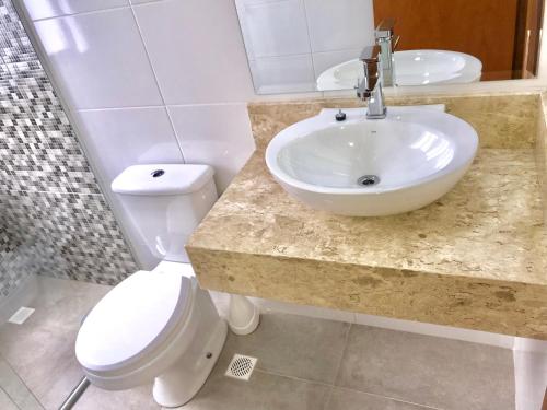 a bathroom with a sink and a toilet at Apartamento no Centro de Gramado in Gramado