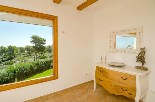 a bathroom with a window and a dresser with a mirror at Villa Miramar, Luxury Villa Rental - Javea in Balcon del Mar